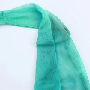 Close-up of green mesh fabric with a fine honeycomb micro-pore texture and machine stitching