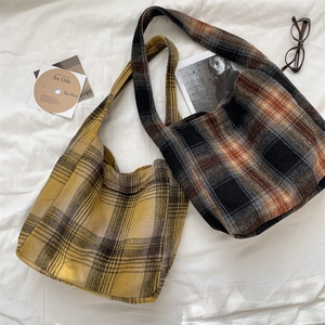 Detail of vintage wool plaid tote bags with wide shoulder straps in a cozy autumn setting