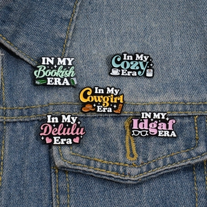 Set of five colorful enamel Era series pins displayed on a blue denim jacket pocket