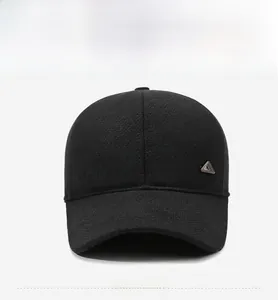 Front view of men's winter baseball cap in black tweed with metallic triangle badge