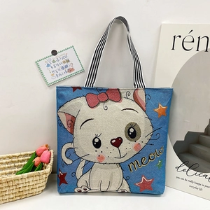 Blue canvas tote bag with cute cartoon cat print and stylish black-white striped handles