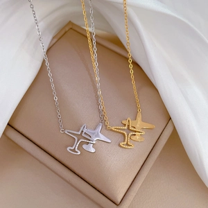 Titanium steel airplane pendant necklace in gold and silver finish on silk background