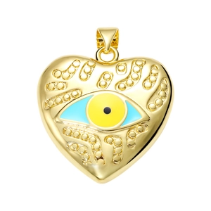 Macro detail of gold heart pendant with evil eye motif and bright metallic luster