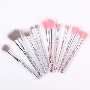 Detail of 10 crystal handle makeup brushes with pink and silver rhinestones on white background