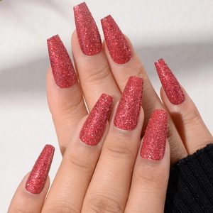 Macro detail of long coffin nails with burgundy glitter finish and matte texture
