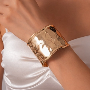Vue détaillée du large bracelet doré à texture martelée et effet de métal liquide poli