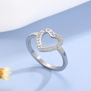 Close-up of heart-shaped hollow ring with micro-paved white zircons on blue background