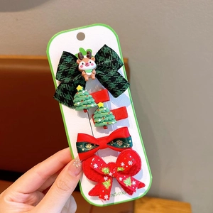 Detailed view of a 5-piece Christmas hair clip set with reindeer and holiday bow motifs