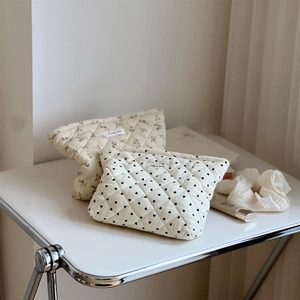 Quilted corduroy makeup bags with floral and heart patterns shown in a lifestyle setting