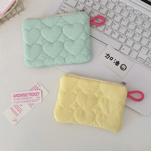Close-up of candy-colored heart quilted mini storage bags in mint green and pale yellow