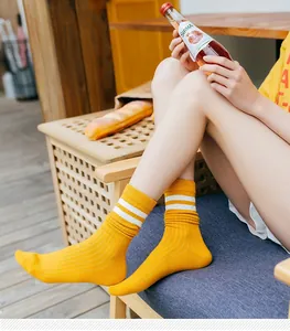 Detail of ginger yellow crew socks with white stripes in a cozy Japanese style setting
