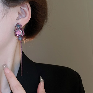 Vintage floral drop earrings with rose pink tassel and blue accents on a female model