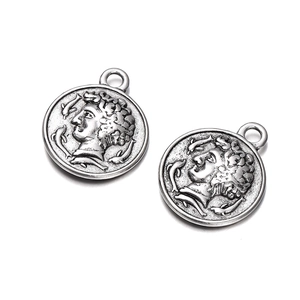 Detailed close-up of antique silver coin pendants featuring classical relief portraits