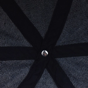 Macro detail of washed denim baseball cap interior showing reinforced stitching and rivet