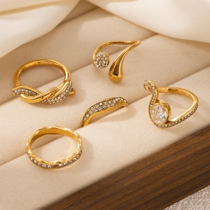 Detailed set of five gold stainless steel rings with clear zircon stones in a jewelry box