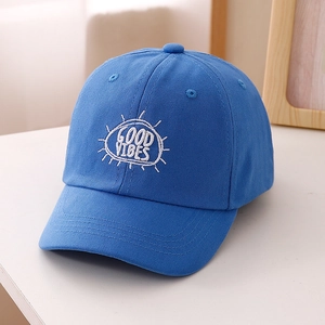 Dettaglio del berretto blu in cotone con ricamo bianco GOOD VIBES e cuciture curate