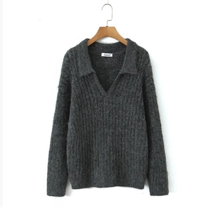 Detailed knit texture of a charcoal grey V-neck pullover sweater on a wooden hanger