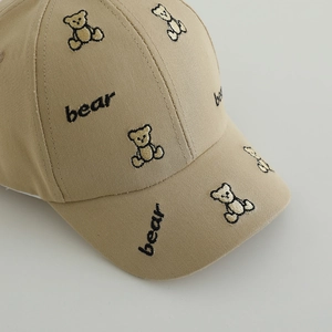 Gros plan sur la casquette en coton kaki montrant la broderie ours et la texture