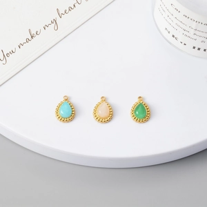 Detailed macro view of bohemian teardrop-shaped natural stone pendants in gold plated frames