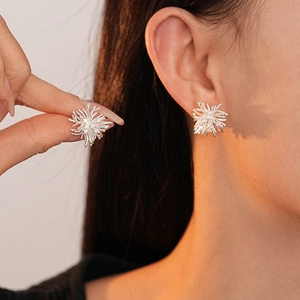 Boucles d'oreilles minimalistes en forme d'étoile argentée avec zircons sur mannequin