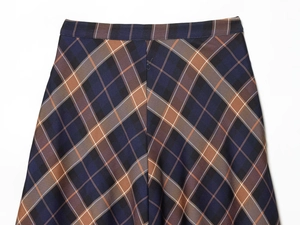 Detailed macro view of the blue and brown plaid fabric texture and waistband stitching