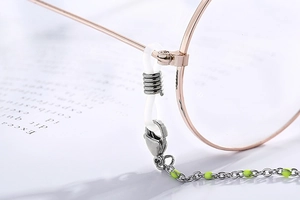 Detail of eyewear chain with neon green beads and secure silicone loops on white background