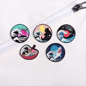 Five-piece black cat and Great Wave enamel pin set on white canvas bag surface
