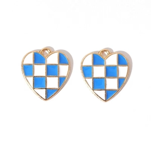 Detailed macro view of two blue and white checkered enamel heart charms with golden edges