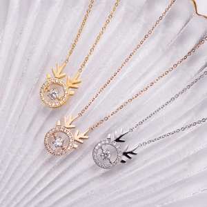 Detailed view of three elk pendants in gold, rose gold, and silver with dancing stones