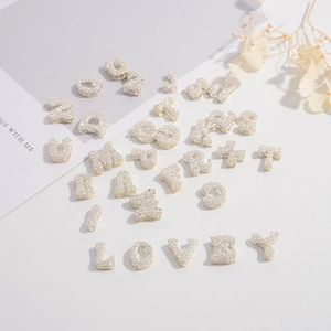 Detailed view of S925 silver gold-plated alphabet charms with pavé set cubic zirconia