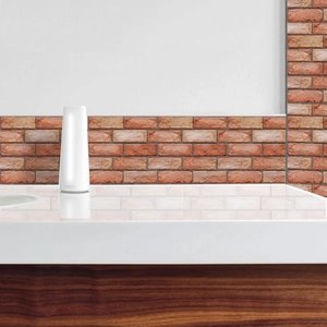 Close-up of a white cylindrical aroma diffuser on a marble counter with red brick background