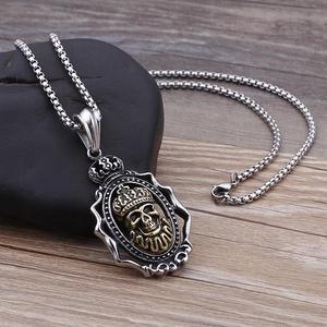 Dettaglio del ciondolo a teschio stile hip hop bicolore oro e argento con corona