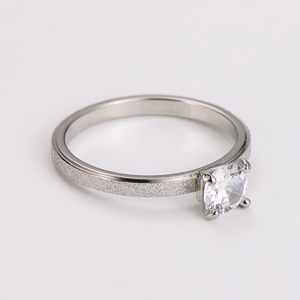 Detailed view of matte frosted silver ring with classic four-prong zircon setting