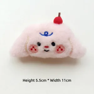 Macro shot of plush puppy accessory with red apple detail showing 5.5cm by 11cm dimensions