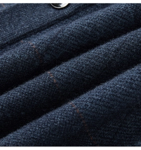 Macro detail of dark blue knit fabric featuring subtle orange-brown checkered patterns