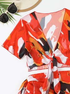 Dettaglio flat lay del top in rete stampata con motivi astratti e accessori per le vacanze