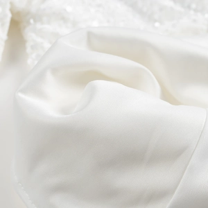 Gros plan macro de la texture élégante du satin blanc pour une mini-robe de luxe