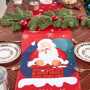Festive red linen Christmas table runner featuring Santa Claus and Merry Christmas text