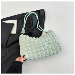 Detailed close-up of light green cloud bag featuring waffle texture and thin shoulder strap