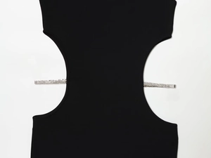 Detalle de vestido negro con aberturas y bandas horizontales con incrustaciones de strass