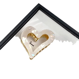 Pearlescent white heart-shaped hair claw clip with gold teeth and black letter I print