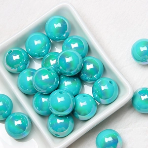 Macro shot of iridescent teal acrylic beads for DIY jewelry and phone chain accessories