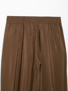 Close-up of brown casual pants featuring an elastic waistband with gathered pleat details