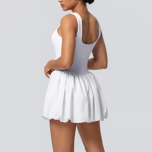 Detail of white tennis dress showing cross-back design and pleated bubble hem skirt