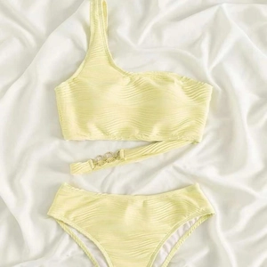 Pale yellow one shoulder bikini set with textured wavy fabric and golden ring detail