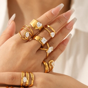 Golden stainless steel geometric ring set with sparkling cubic zirconia on a female hand