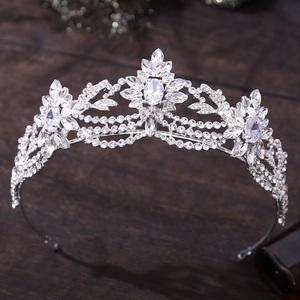 Detailed view of silver bridal crown with floral zircon stones on a dark background