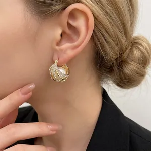 Boucles d'oreilles géométriques dorées avec zircons brillants et perle de sirène
