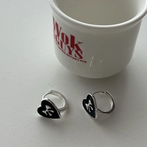 Detail view of 925 silver bow heart earrings with black enamel and silver edges