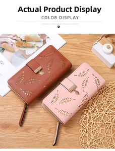 Detail of leaf cutout pattern on leather wallets with decorative metal leaf zipper pull